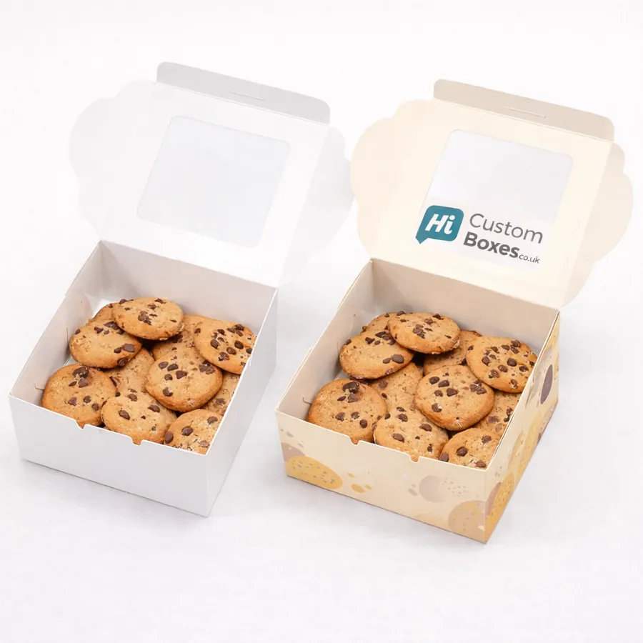 Two open square biscuit boxes with windowed lids- filled with various chocolate chip cookies- class=